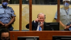 Ratko Mladic berusaha melucu dengan meniru wartawan yang mengambil fotonya di Den Haag, Selasa (8/6).