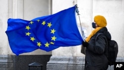 Seorang demonstran anti-Brexit memegang bendera Uni Eropa di Parliament Square, di London, 16 Desember 2020. (Foto: AP)