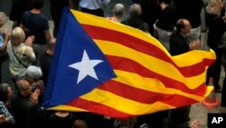 An Independence flag waves during a demonstration outside the regional presidential palace in Sant Jaume Square in Barcelona, Spain, Nov. 2, 2017. Thousands of people rallied in a show of support for ousted Catalan cabinet members and lawmakers appearing in court in Madrid for questioning as part of an investigation into possible rebellion charges for having declared the region’s independence from Spain. 