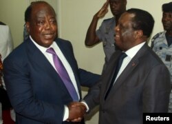 FILE - Charles Konan Banny (L), independent candidate for the 2015 presidential election, shakes hands with Independent Electoral Commission (CEI) President Youssouf Bakayoko (R).
