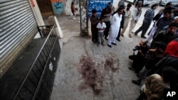 Local residents and members of the news media gather at spot where Nasiruddin Haqqani, a senior leader of the feared militant Haqqani network, was assassinated at an Afghan bakery in the Bhara Kahu area on the outskirts of Islamabad, Pakistan, Nov. 11, 20