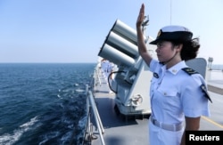 资料照：中俄海军在广东湛江海域举行联合军演后，一名中国海军士兵向俄罗斯舰队举手告别。（2016年9月19日）