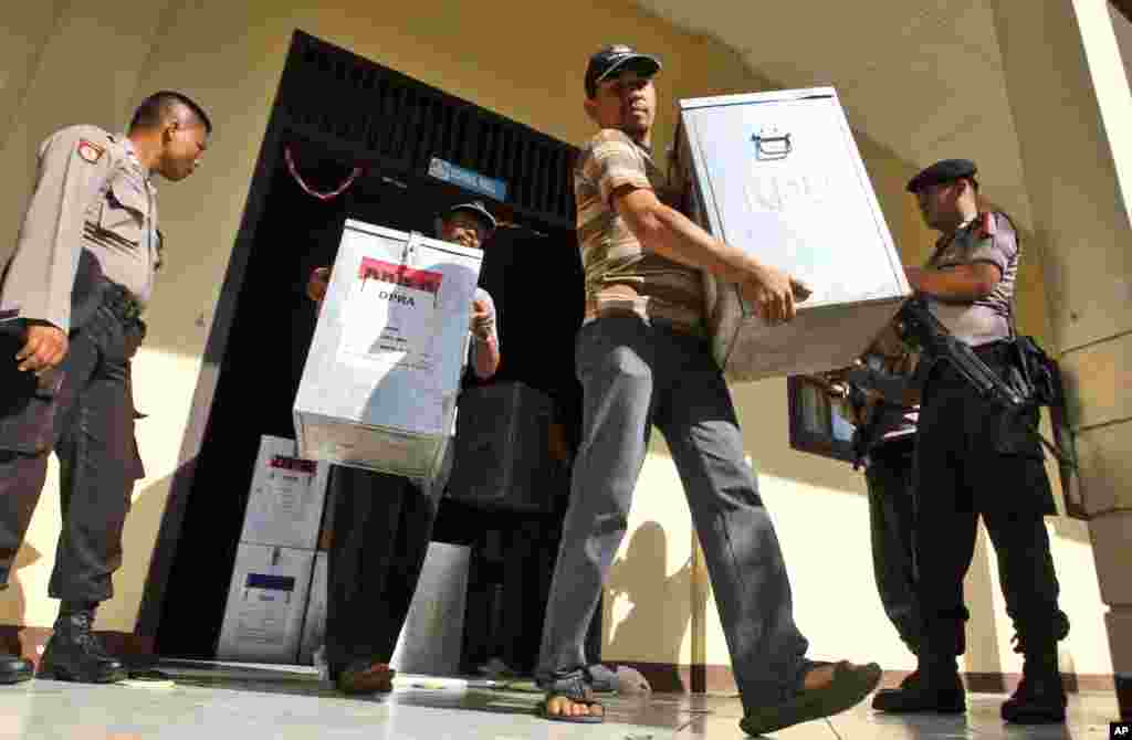 Armed police officers stand guard as election officials carry ballot boxes to be distributed to polling stations at a local government office in Banda Aceh, Indonesia, April 8, 2014.&nbsp;
