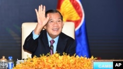 រូបឯកសារ៖ លោក​នាយក​រដ្ឋមន្ត្រី ហ៊ុន សែន លើកដៃ​នៅពេល​លោក​ចូលរួម​កិច្ចប្រជុំ​តាម​ប្រព័ន្ធ​អ៊ីនធឺណិត​នៃ​កិច្ចប្រជុំ​កំពូល​ពិសេស​អាស៊ាន-ចិន នៅ​វិមាន​សន្តិភាព រាជធានី​ភ្នំពេញ ប្រទេស​កម្ពុជា កាលពី​ថ្ងៃទី២២ ខែវិច្ឆិកា ឆ្នាំ២០២១។