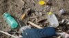 FILE - Plastic bottles and a flip-flop lie on the sand at Maccarese beach in Rome, Italy, Nov. 21, 2018. 