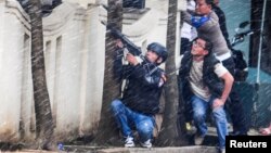 A police officer points his weapon near a government office following an explosion in Bandung, West Java, Indonesia, Feb. 27, 2017.
