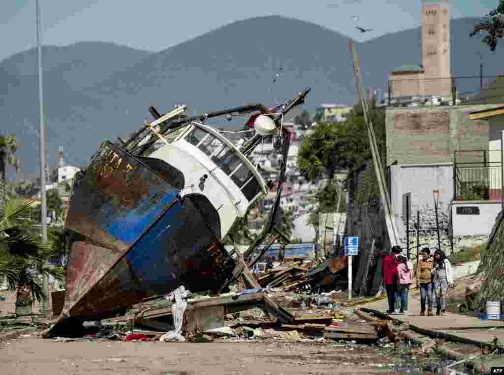 A fishing boat that was ran aground by the sea while moored in the port of Coquimbo, some 445 km north of Santiago, during the eve&#39;s earthquake, Chile, Sept. 17, 2015. A million people were evacuated after an 8.3-magnitude quake struck offshore in the Pacific, killing at least 12 people and triggering tsunami waves along its northern coast.