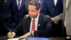 អភិបាល​រដ្ឋ​ញូវយ៉ក លោក Andrew Cuomo ចុះ​ហត្ថលេខា​លើ​ផែន​ការ​សម្រាប់​ការ​សិក្សា​ឥត​គិត​ថ្លៃនៅ​សាកវិទ្យាល័យ​ និង​កំណែ​ទម្រង់​យុត្តិធម៌​សម្រាប់​អនីតិជន​ នៅ​ទីក្រុង​ញូវយ៉ក កាល​ពី​ថ្ងៃទី​១០ ខែ​មេសា។
