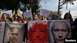 Suku Kurdi yang tinggal di Siprus meneriakkan slogan-slogan selama aksi demo menentang serangan Turki terhadap pasukan Kurdi di Suriah barat laut, 1 Maret 2018, di luar Kedutaan Besar Rusia di Nicosia, Siprus.