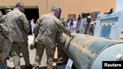 FILE - Saudi-led coalition officials show U.S. Central Command chief General Kenneth McKenzie an exhibit of weapons and missiles used in Houthi attacks against Saudi Arabia, in Riyadh, Saudi Arabia, July 18, 2019.