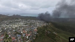 Asap membubung dari pesawat marinir Osprey setelah mendarat secara darurat di Markas Angkatan Udara Bellows, dekat Waimanalo. Hawaii (17/5). (AP/Brandon Kelly)