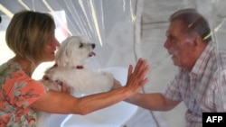 Une femme rend visite à son mari le 25 mai 2020 dans une maison de retraite à Bourbourg, où une double entrée a été installée pour permettre des visites sans risque de contamination au coronavirus. (Photo DENIS CHARLET / AFP)