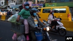 រូបឯកសារ៖ ពលរដ្ឋកម្ពុជាដែលមានពាក់ម៉ាស់ការពារការឆ្លងជំងឺកូវីដ១៩ ធ្វើដំណើរតាមម៉ូតូនៅលើដងវិថីមួយក្នុងរាជធានីភ្នំពេញ កាលពីថ្ងៃទី១ ខែកុម្ភៈ ឆ្នាំ២០២១។