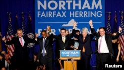 Gubernur Virginia terpilih, Ralph Northam (tengah) merayakan kemenangannya bersama (dari kiri:) Gubernur Terry McAuliffe, Letnan Gubernur Pick Justin Fairfax, Jaksa Agung Mark Herring dan Senator Mark Warner, pada malam pemilihan Gubernur Virginia di kampus dari George Mason University di Fairfax, Virginia, 7 November 2017.