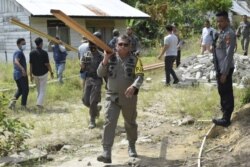 Kapolda Sulawesi Tengah Irjen Pol Abdul Rakhman Baso memikul balok kayu yang akan digunakan dalam pembangunan kembali rumah warga yang sebelumnya dibakar kelompok teroris MIT, Kamis , 3 Desember 2020. (Foto : Humas Polda Polda Sulawesi Tengah)