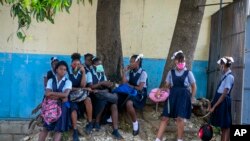 Student wait their turn to enter Lycee Marie Jeanne school on first day of school since the COVID-19 pandemic in Port-au-Prince, Haiti, Monday, Aug. 17, 2020. (AP Photo/Dieu Nalio Chery)