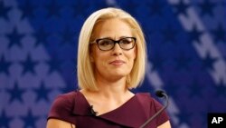 FILE - U.S. Rep. Kyrsten Sinema, D-Ariz., goes over the rules in a television studio prior to a televised debate with U.S. Rep. Martha McSally, R-Ariz., in Phoenix, Oct. 15, 2018.