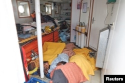 Migrants lie on the floor on the Alan Kurdi migrant rescue vessel, run by the German charity Sea-Eye, in the Mediterranean sea, April 3, 2019.