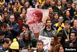 FILE - People protest after former president Carles Puigdemont was detained in Germany, during a demonstration held by pro-independence associations in Barcelona, Spain, March 25, 2018.
