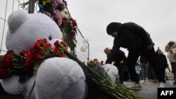 People lay flowers at a makeshift memorial in front of the Crocus City Hall on March 23, 2024, a day after a deadly attack in suburban Moscow that killed at least 115 people.