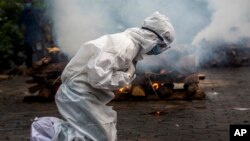 Seorang wanita menangis saat berdoa sebelum kremasi kerabat yang meninggal karena COVID-19 di Gauhati, India, 2 Juli 2021. Varian Delta pertama kali ditemukan di India dan kini menyebar di sejumlah negara. (Foto: AP)