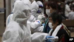 Evacuees are screened for radiation contamination at a testing center Tuesday, March 15, 2011, in Koriyama city, Fukushima Prefecture, northern Japan, four days after a massive earthquake and tsunami struck the country's north east coast.
