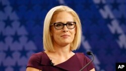 FILE - U.S. Rep. Kyrsten Sinema, D-Ariz., goes over the rules in a television studio prior to a televised debate with U.S. Rep. Martha McSally, R-Ariz., in Phoenix, Oct. 15, 2018.