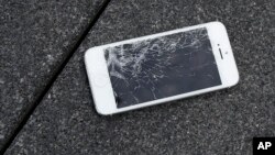 FILE - An Apple iPhone with a cracked screen after a drop test is seen at the offices of SquareTrade in San Francisco.