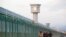Workers walk by the perimeter fence of what is officially known as a vocational skills education center in Dabancheng in Xinjiang Uighur Autonomous Region, China, Sept. 4, 2018. 