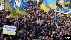 Students hold placards and flags as thousands rally in the western Ukrainian city of Lviv during a rally of pro-European supporters, Nov. 27, 2013.