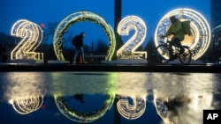 La gente pasa junto a los números "2020" instalados para celebrar la próxima Navidad y Año Nuevo en Moscú, Rusia.