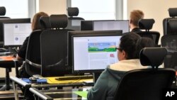 Employees of the Competence Call Center (CCC) work for the Facebook Community Operations Team in Essen, Germany, Thursday, Nov. 23, 2017. (AP Photo/Martin Meissner)