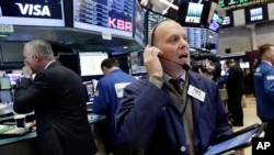 Trader Daniel Leporin, right, works on the floor of the New York Stock Exchange, May 17, 2017. 