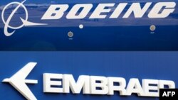 Kombinasi foto logo Boeing dan Embraer, 21 Desember 2017.