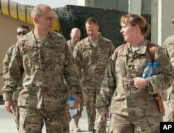 In this image provided by the U.S. Air Force, Lt. Gen. Jeffrey Harrigian, who is currently head of U.S. Air Force's operations throughout the region, walks with Lt. Col. Joy Boston, 455th Expeditionary Operations Support Squadron commander at Bagram Airfi