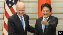 U.S. Vice President Joe Biden, left, is welcomed by Japanese Prime Minister Shinzo Abe prior to their talks at Abe's official residence in Tokyo, Dec. 3, 2013. 