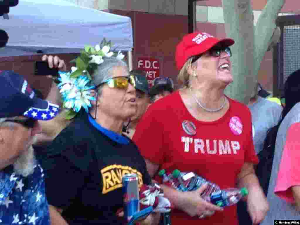 A pro Trump supporter screams across a metal barrier at people protesting the visit to Phoenix by President Donald Trump, Aug. 22, 2017.