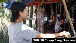 May Khine Oo, 30, stands in front of her family's grocery store in Mon state, Myanmar, July 20, 2017. 