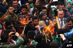 Syrian Kurds light torches as they celebrate the Nowruz spring festival in the capital Damascus, March 21, 2015.