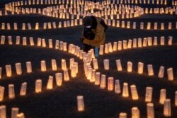 Seorang pengunjung mengambil gambar lentera kertas di "taman lilin Washi", sebuah peringatan untuk mengirim pesan dari wilayah Tohoku, di distrik Roppongi Tokyo, 11 Maret 2021, dalam peringatan 10 tahun tsunami dan bencana nuklir.