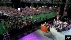 Photographers and spectators approach the stage as Rev. Billy Graham preaches on the first night of his three-day crusade at Flushing Meadows Corona Park in the Queens borough of New York Friday, June 24, 2005. (AP Photo/Julie Jacobson)