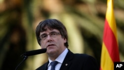 Pemimpin Catalonia, Carles Puigdemont memberikan keterangan kepada media setelah upacara peringatan 77 tahun wafatnya pemimpin Catalonia, Lluis Companys di Pemakaman Montju, Barcelona, Spanyol, Minggu (15/10). 
