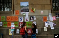 People stand in front of banners displayed on the wall regarding the independence referendum, outside the public university in Barcelona, Spain, Sept. 26, 2017.