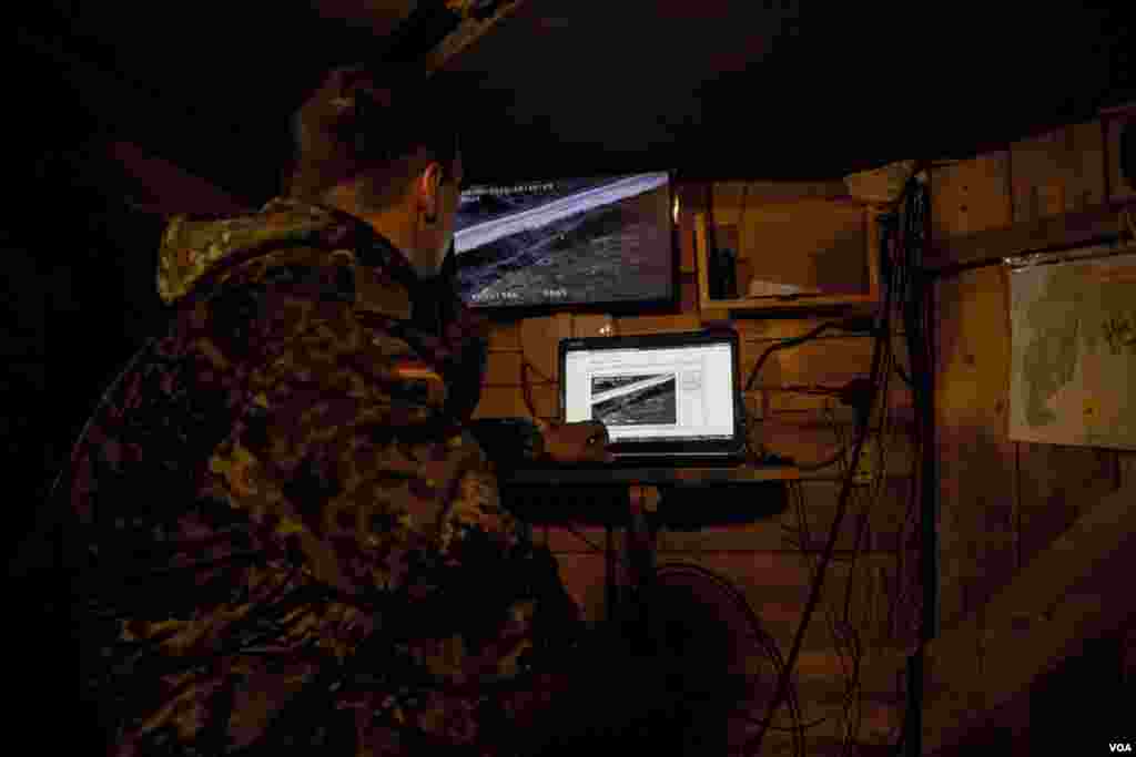 A Ukrainian soldier in an underground bunker uses spy camera equipment to observe the strategic road toward rebel-held Donetsk Airport where fighting continues. (Adam Bailes/VOA)
