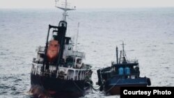 동중국해 공해상에서 21일과 22일 북한 선적 유조선 ‘유평 5호’와 국적 불명의 선박이 나란히 서서 호스로 석유 등 물품을 옮기는 있는 장면. 일본 외무성 사진제공. 