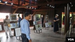 អ្នក​ចូល​រួម​ទស្សនា​កំពុង​តែ​អងេ្កត​មើល​រូបថត​ ​និង​រឿងរ៉ាវពិត​របស់​អ្នក​តស៊ូ​មតិដើម្បី​សន្តិភាព​នៅ​កម្ពុជា​ថ្ងៃអង្គារ​ ទី២៣ ខែតុលា ​ឆ្នាំ២០១៨។ (ហោ ស៊ិញហ៊ួរ/VOA)