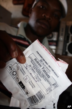 An HIV-infected patient holds a packet of antibiotics at a clinic in Mangaung