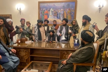 រូប​គំនូរ​ឧទ្ធម្ភាគចក្រ​អាមេរិក​ហោះ ខណៈក្រុម​សកម្ម​ប្រយុទ្ធ​តាលីបង់​ម្នាក់អង្គុយ​លើ​រថក្រោះ​អាមេរិក​ដែល​ទុក​ចោល ​អម​ដោយដើម​​​ផ្កា​​អាភៀន។