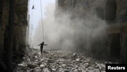 បុរស​ម្នាក់​ដើរ​កាត់​កម្ទេច​អគារ​បន្ទាប់​ពីមាន​ការ​វាយ​ប្រហារ​តាម​អាកាស​ទៅ​លើ​តំបន់​ដែល​កាប់​កាប់​ដោយ​ពួក​ឧទ្ទាម​នៅ​ជិត​ក្រុង​ Aleppo កាល​ពី​ថ្ងៃទី​២៥ ខែកញ្ញា ឆ្នាំ២០១៥។