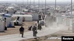 Syrian refugees walk at the Al Zaatari refugee camp in the Jordanian city of Mafraq, near the border with Syria, December 7, 2014.